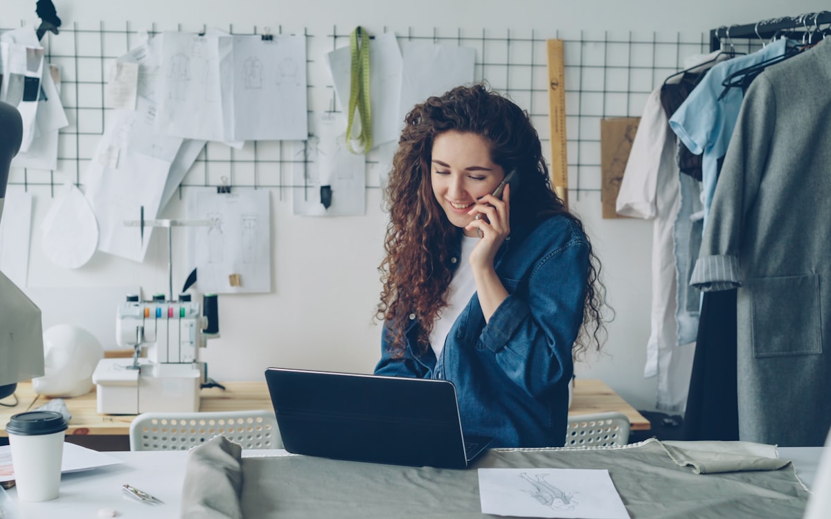 Small-business owner working on a laptop at a counter, ready to update their own site